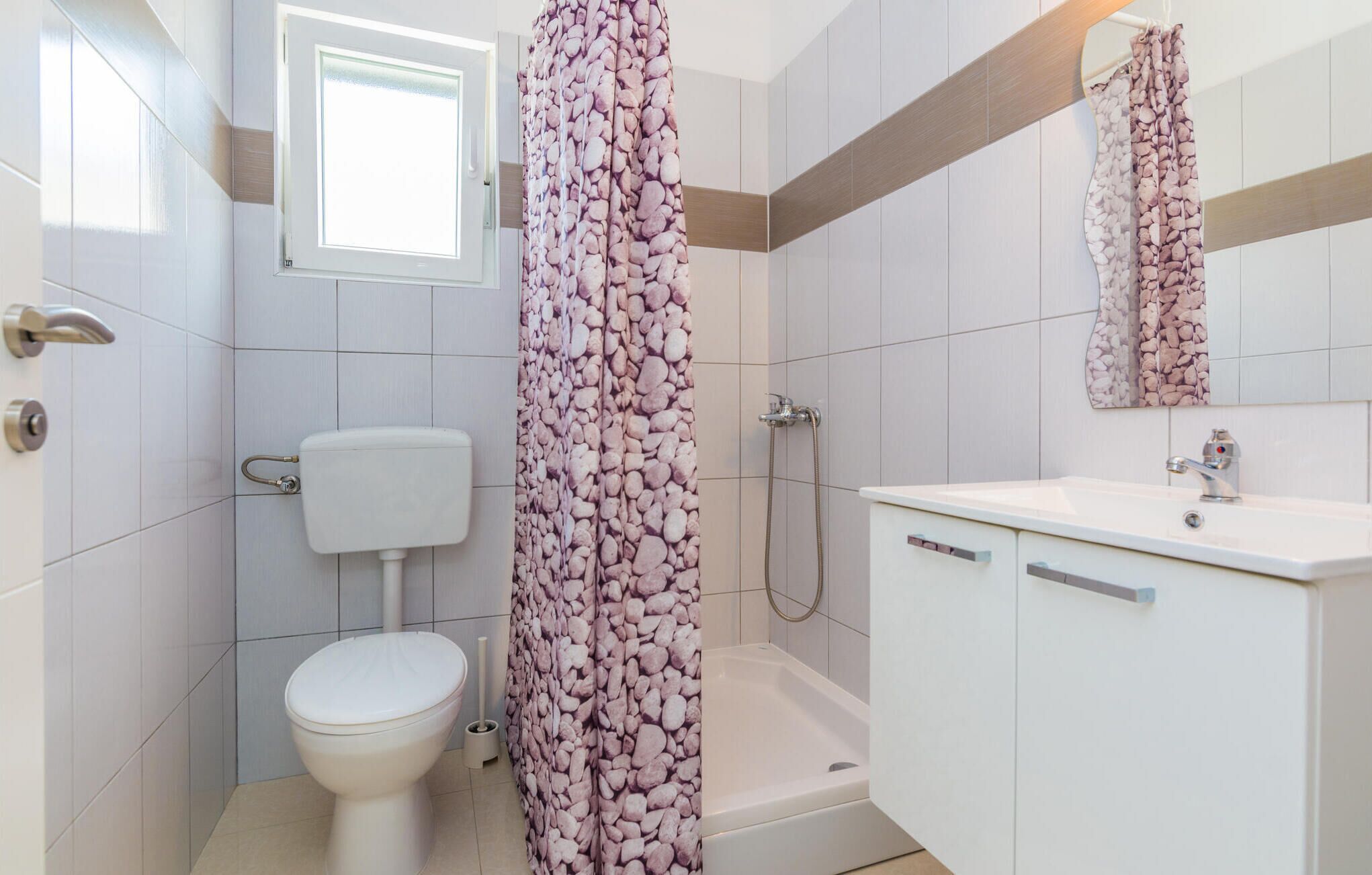 Een badkamer met toilet, douche, bad en wastafel.