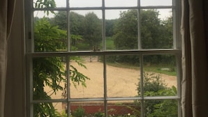 A window with a view of a garden and a dirt path. - Waldegrave farm (Bury St Edmunds)
