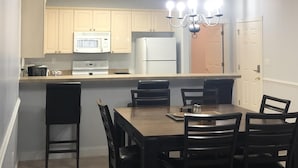 A modern kitchen with a central island, a dining table with chairs, and a chandelier. -  Beautiful, Clean condo, new furniture beds carpet TVs. Lake view, private Wifi  (Myrtle Beach)