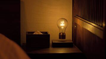 A bedside table with a light bulb, a tissue box, and a wooden panel.
