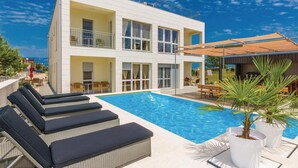 A modern building with a pool, outdoor seating, and a covered area. - 1 bedroom cozy apartment in Vir (Vir)