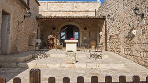 A stone building with a courtyard, featuring a central fountain, seating area, and stone walls. - Agriturismo Al Casale (Ragusa)