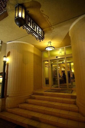 A hotel entrance with a staircase leading to a revolving door.