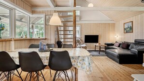 A spacious living area with a dining table, black chairs, a black leather sofa, and a TV. - Awesome home in Hovborg with WiFi (Hovborg)