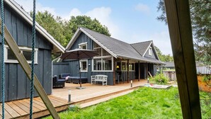 A two-story house with a covered porch, a deck, and a swing set. - Awesome home in Hovborg with WiFi (Hovborg)