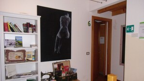 A room with a bookshelf, a sewing machine, and a framed artwork on the wall. - Podere Vedelago (Vedelago)