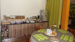 A kitchen with a wooden counter, jars of food, a refrigerator, and a dining table with placemats. - Podere Vedelago (Vedelago)