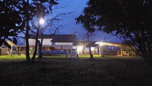 A building with a covered porch and a fenced yard at dusk. - Podere Vedelago (Vedelago)