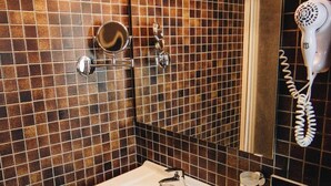 A bathroom with a white sink, a hairdryer, and a mirror. - Pension Baranek (Kaprun)