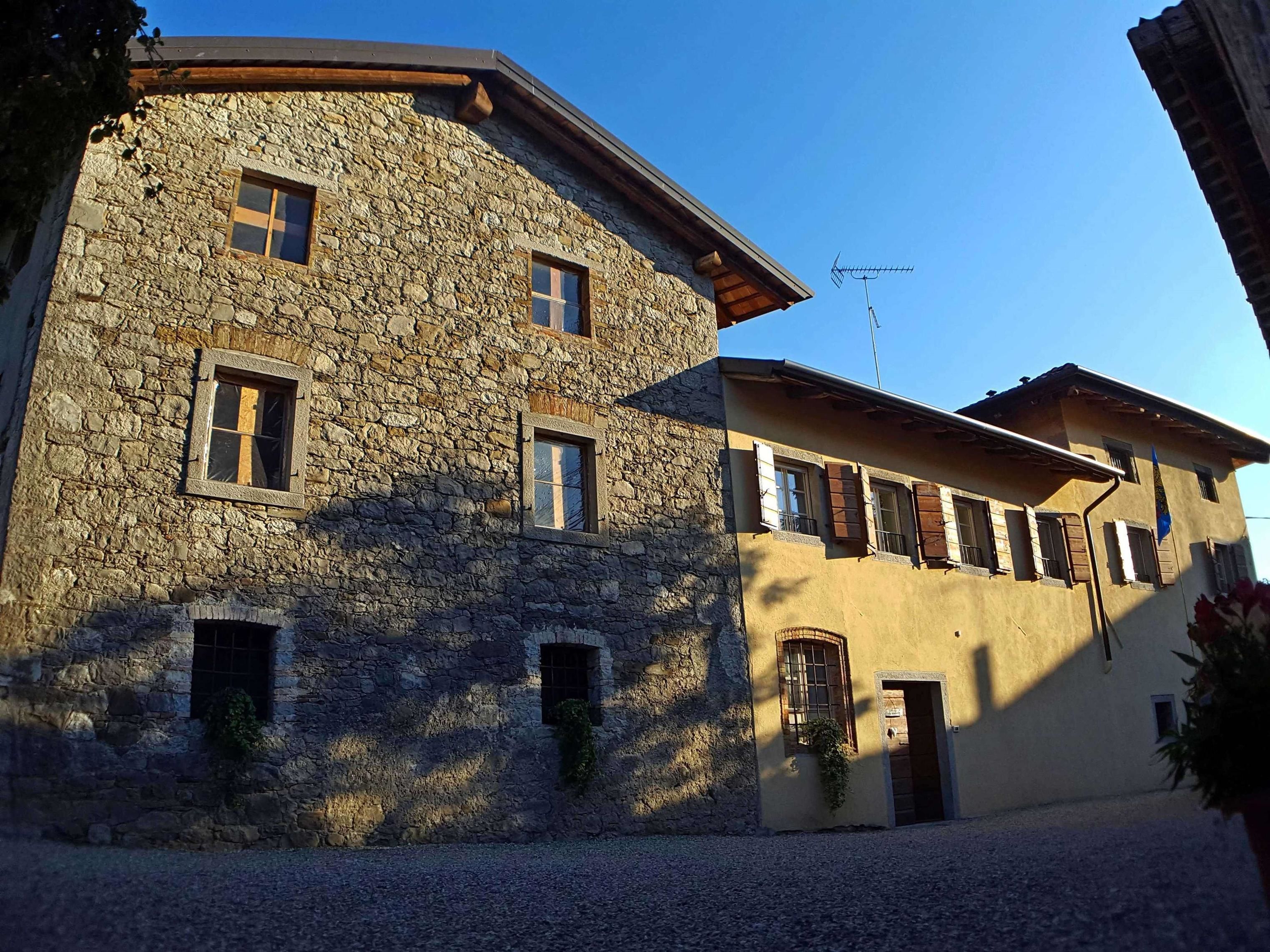 A stone building with multiple windows and a flat roof.