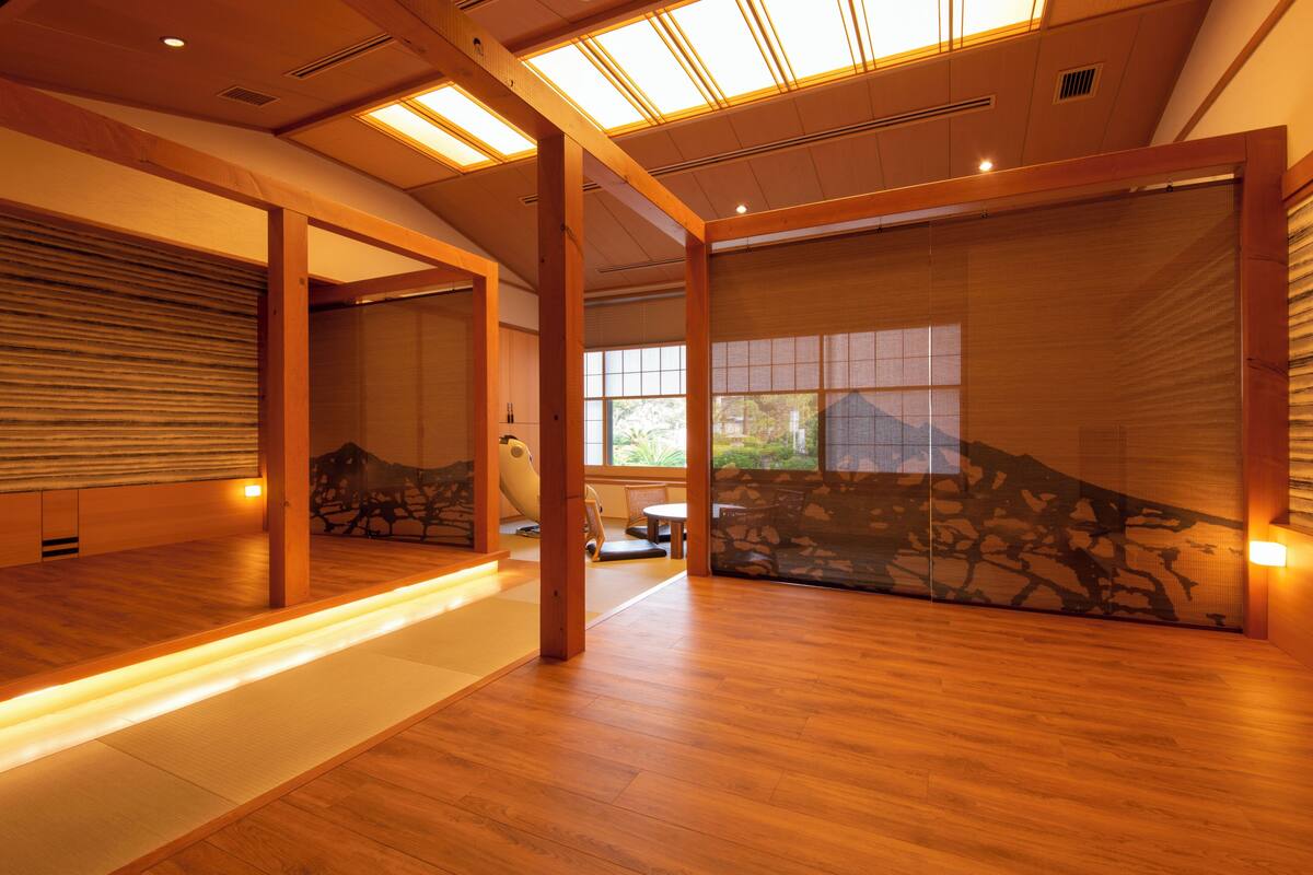 Amplia habitación con piso de madera, un gran ventanal corredera y vistas al exterior.