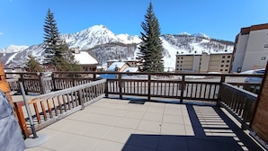 A balcony with a view of snow-covered mountains, a wooden railing, and tiled flooring. - Luxury Apartment for 6 - Terrace - Montgenèvre (Montgenèvre)