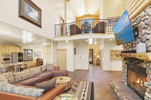 A spacious living area with a fireplace, a dining area, and a kitchen.