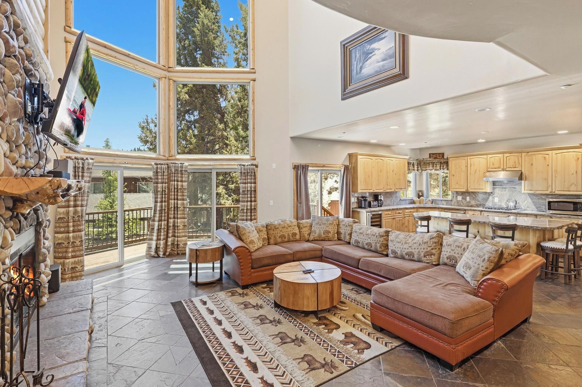 A spacious living room with a large sectional sofa, a fireplace, and a view of the outdoors.