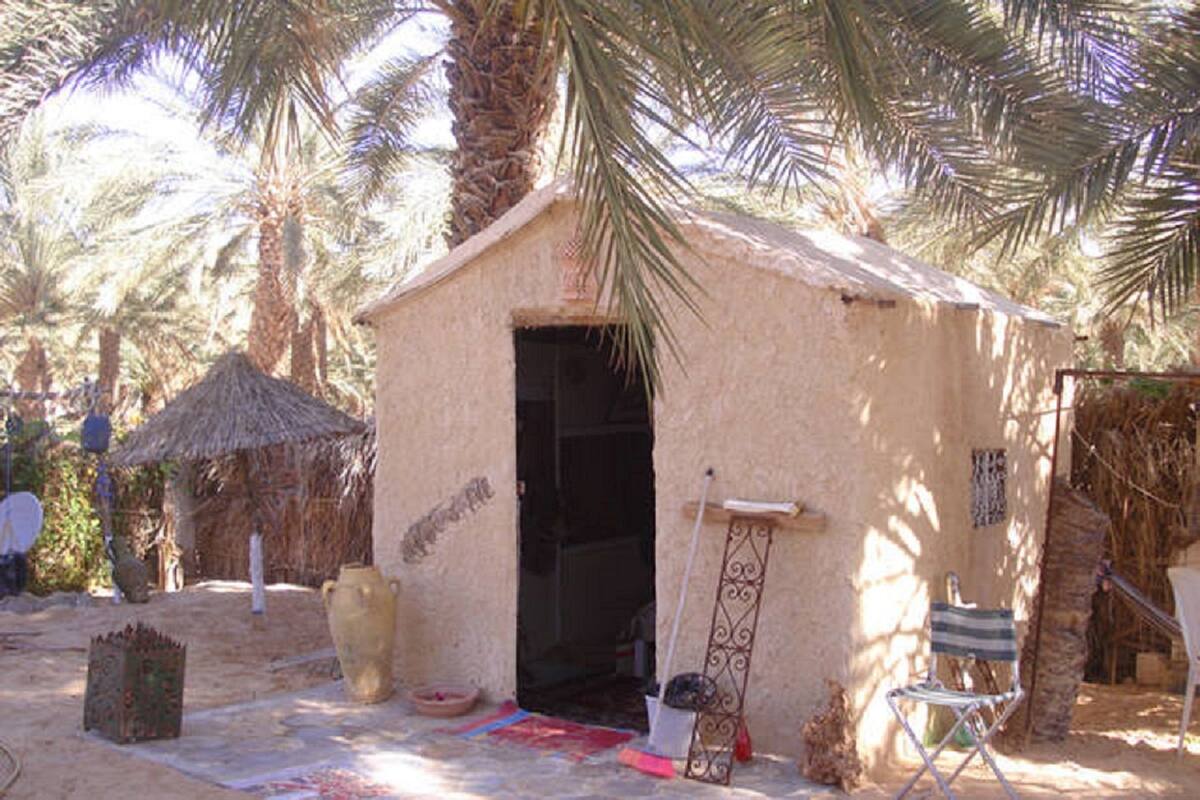 Un petit bâtiment d’un seul étage, doté d’un toit de chaume, d’une porte et d’un petit porche.
