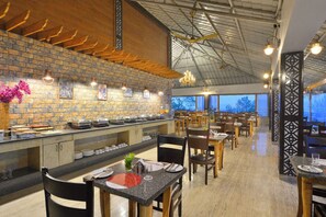 Ein Restaurant mit Backsteinwand, Holzbalkendecke und einer Buffet-Theke.