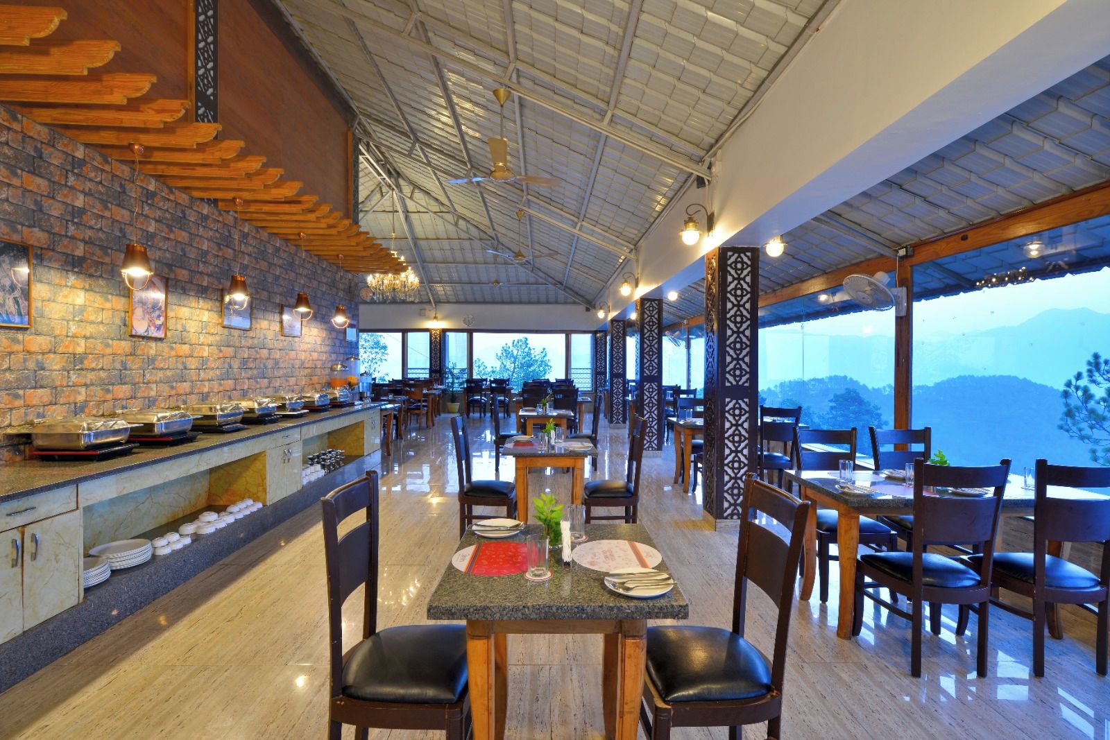 A restaurant with a brick wall, wooden ceiling, and tables with chairs.