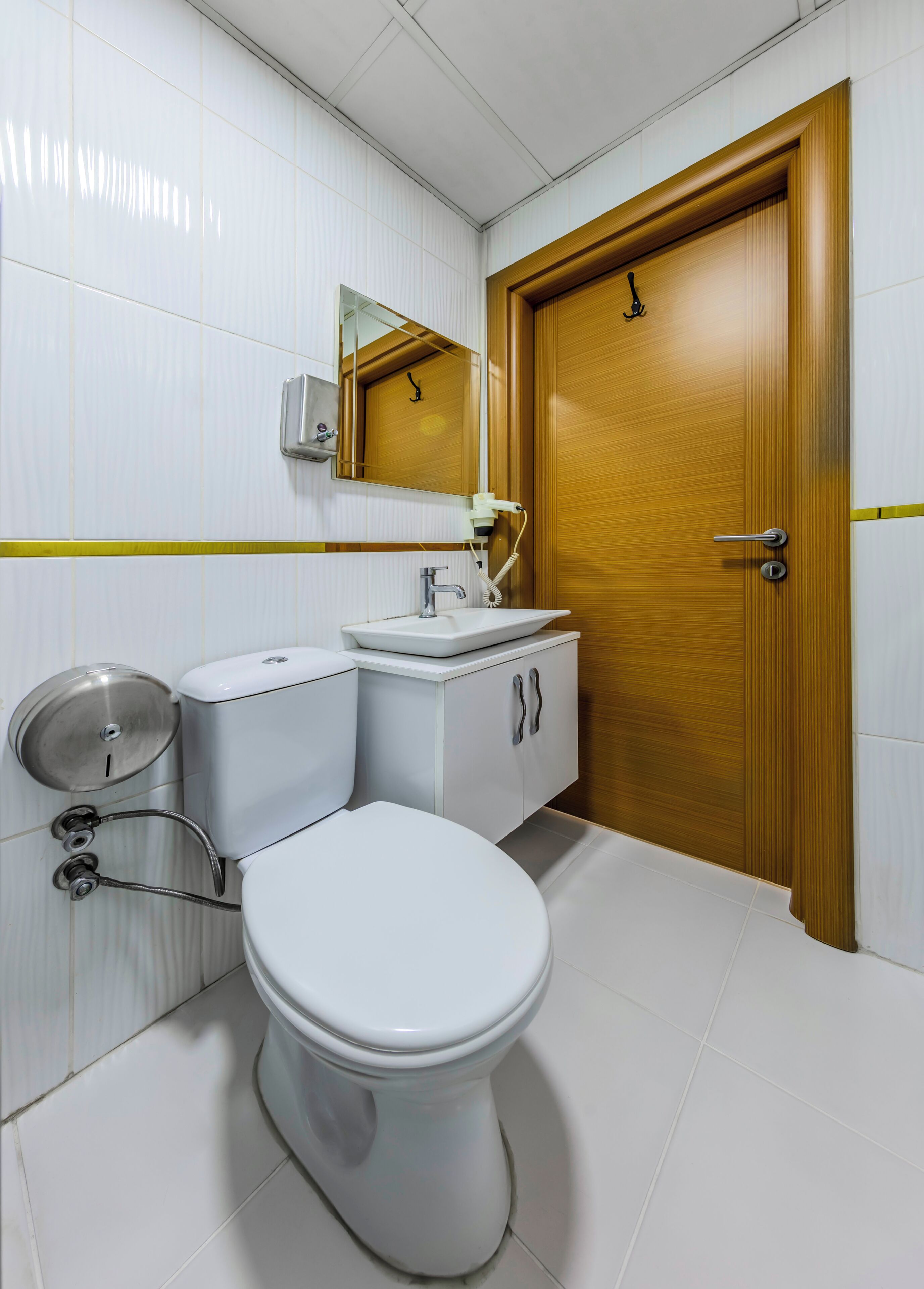 Un baño moderno con inodoro, lavamanos y espejo.