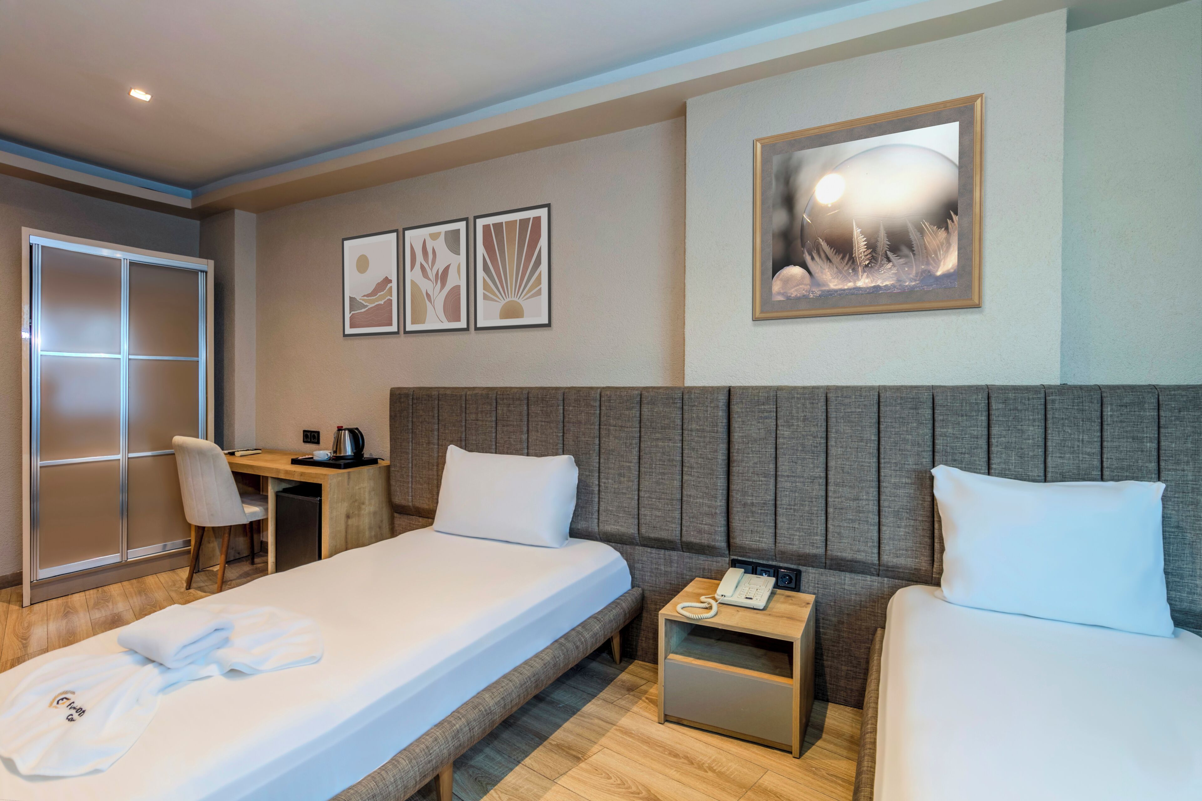 A hotel room with a bed, bedside tables, a desk, and a chair.
