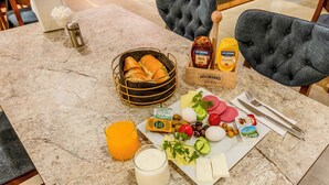 A breakfast setting with bread, eggs, cheese, and condiments on a marble table. - Evim Hotel (Corlu)