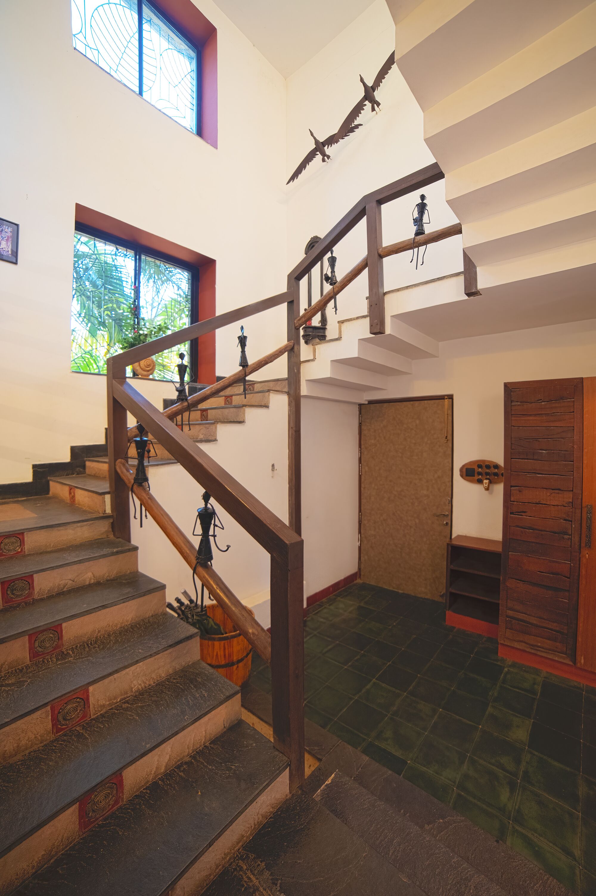 Un escalier avec des rampes en bois et un sol recouvert de carreaux verts.