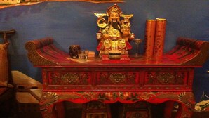 Un autel traditionnel orné d’une statue, d’encens et d’objets rituels.
