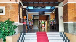 A hotel entrance with a red carpet, a staircase, and a wooden ceiling. - Sabai Hotel (Nakhon Ratchasima)