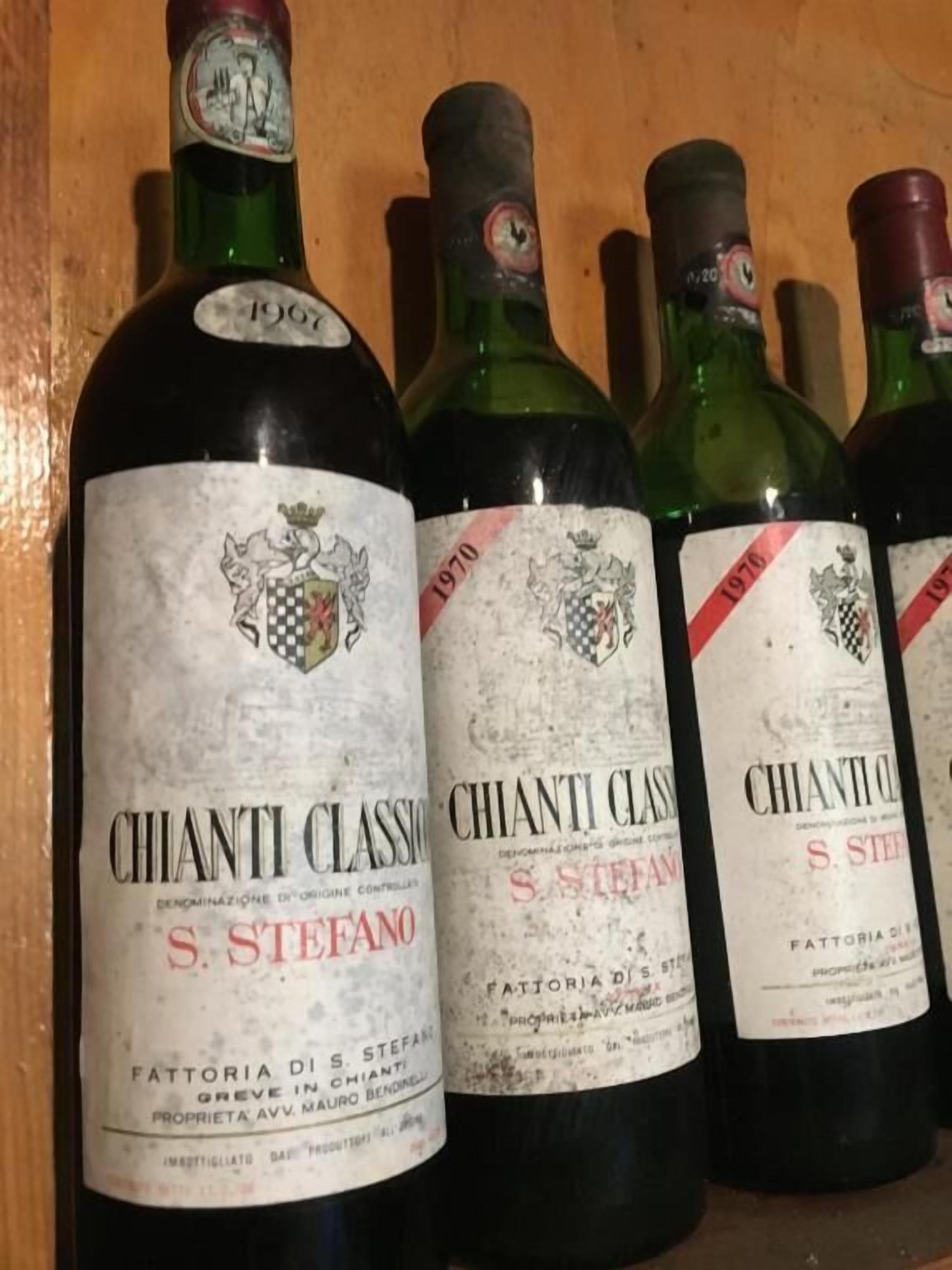 Une rangée de bouteilles de vin dont les étiquettes indiquent « Chianti Classico » et « S. Stefano ».