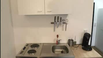 Appartement | Privékitchenette | Een koelkast, een kookplaat, kookgerei, borden en bestek