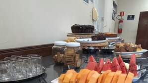 A buffet table with various fruits and desserts. - Hotel Caiçara (Santos)