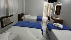 A hotel room with two beds, a desk, a mirror, and a television. - Hotel Caiçara (Santos)
