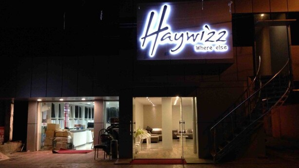 A building with a neon sign reading "Haywizz" and a glass entrance. - Haywizz Port Blair - Port Blair (Port Blair)