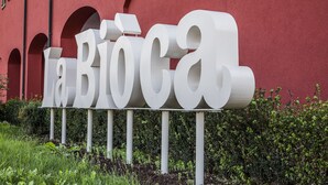 A large white sign with the text "la Biòca" in front of a red building with arched windows. - Agriturismo La Biòca (Serralunga d'Alba)