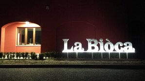 A building with a sign reading "La Biòca" illuminated at night. - Agriturismo La Biòca (Serralunga d'Alba)