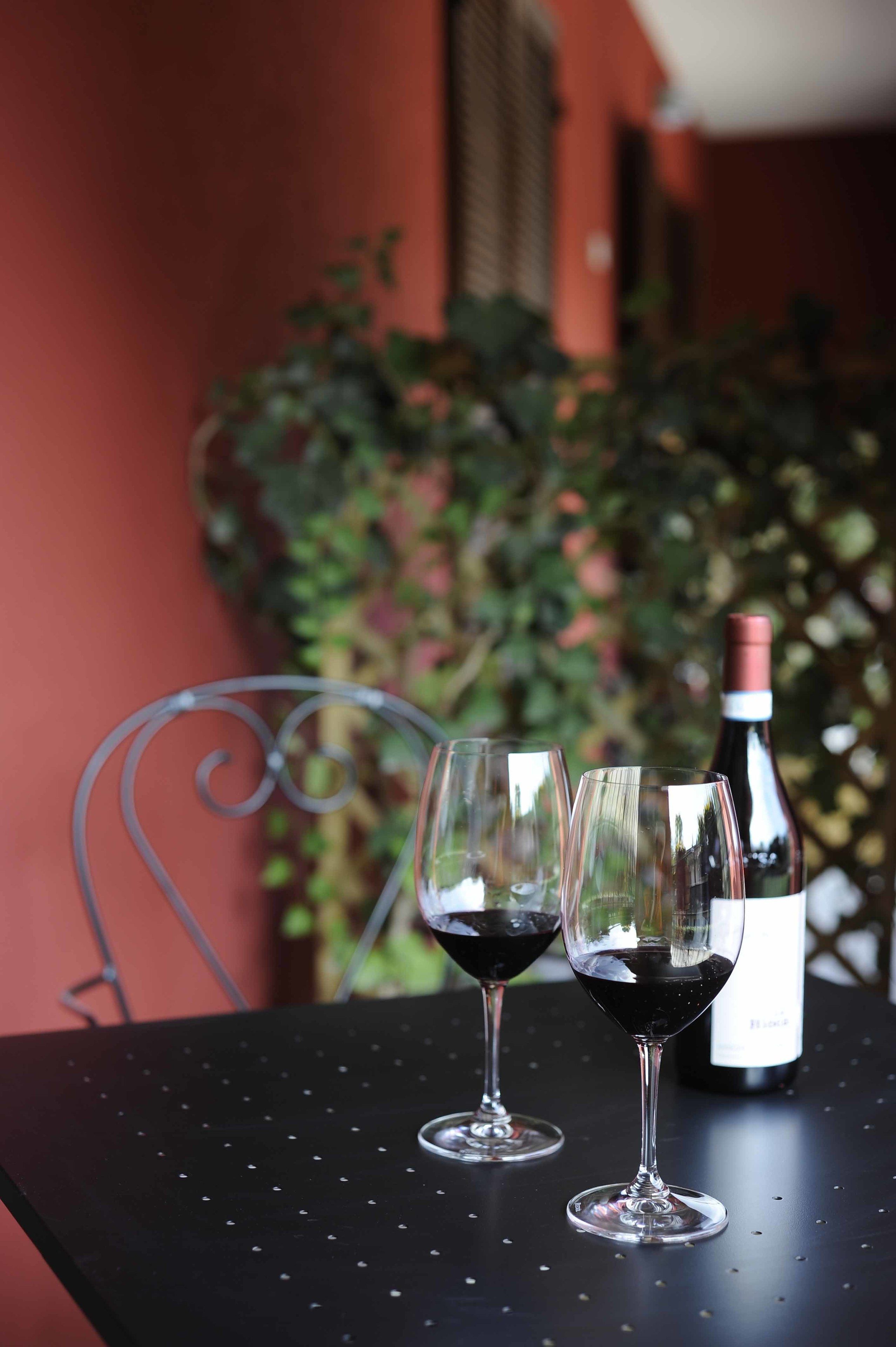 Dos copas de vino sobre una mesa con una botella.