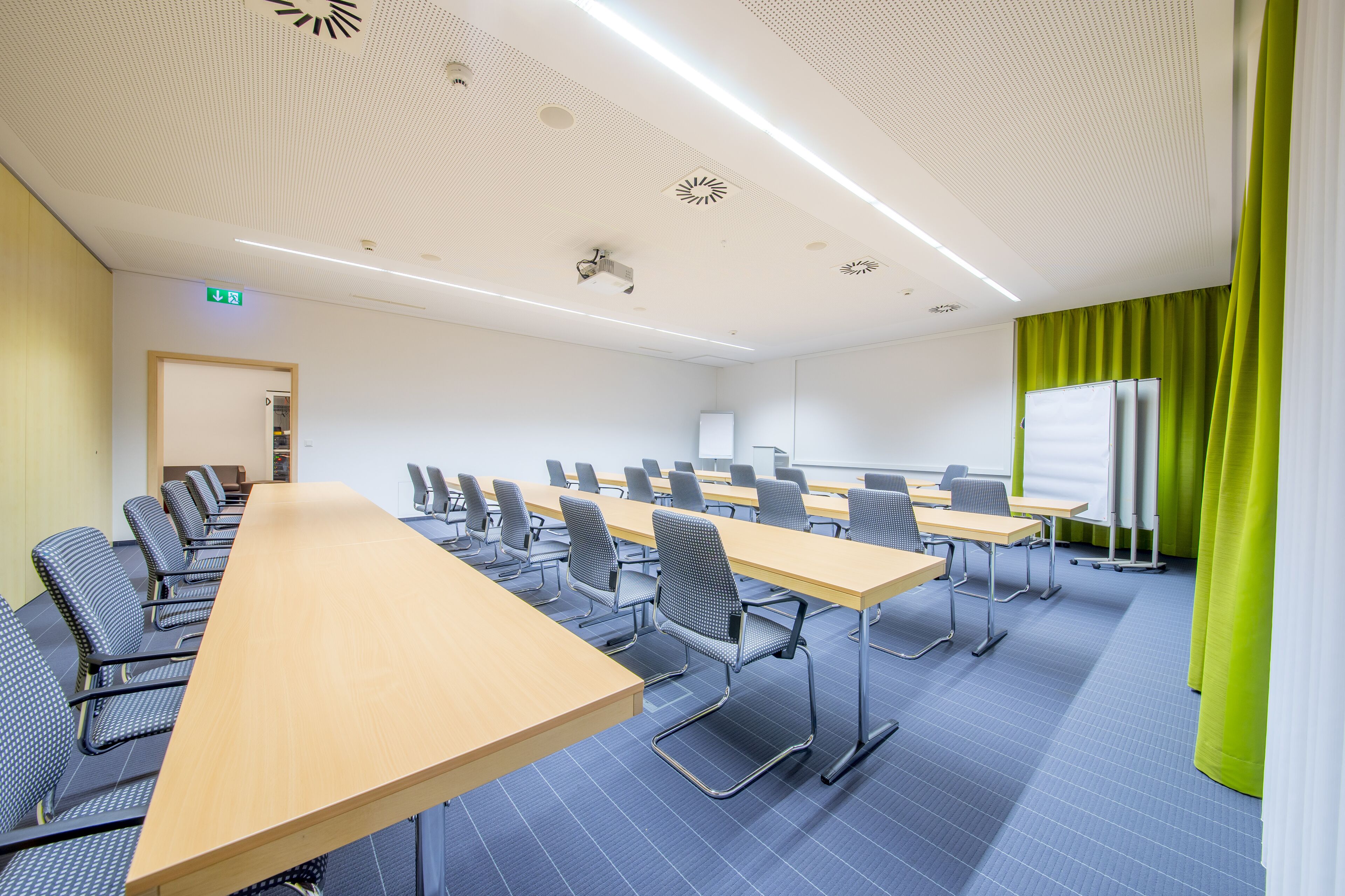 A conference room with a long table and chairs, a whiteboard, and a projector.