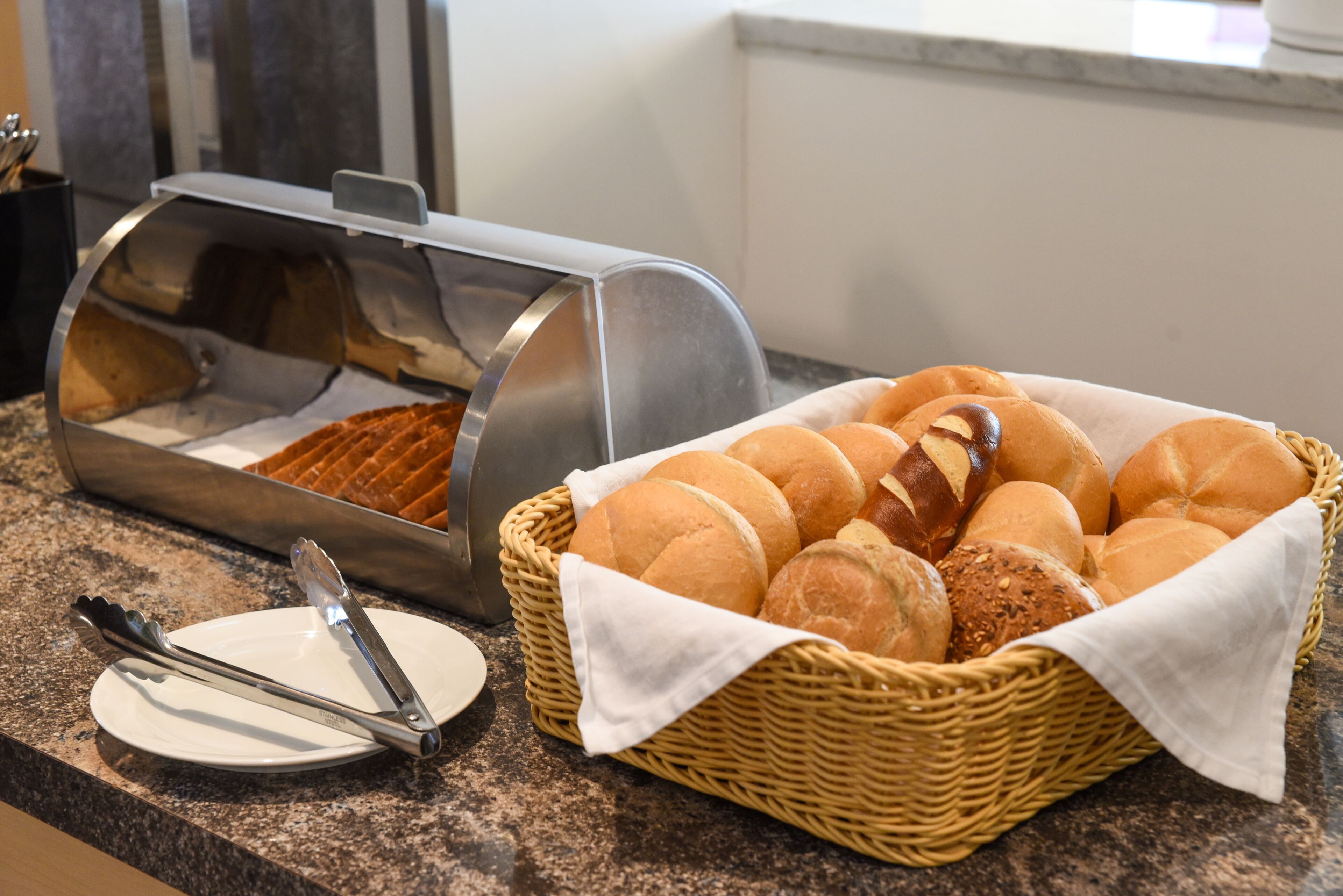 A buffet setup with a bread basket and a bread display.