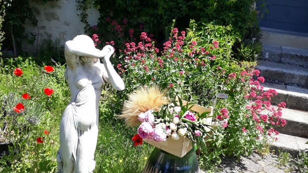 A statue in a garden with a building in the background. - Chambre d'hôtes La Margotte (Forcalquier)