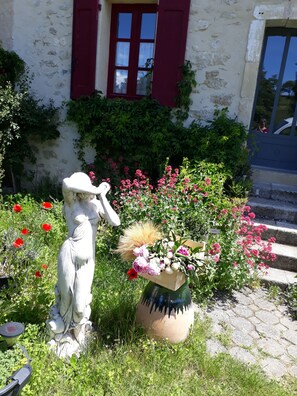 Une statue dans un jardin, avec un bâtiment en arrière-plan.