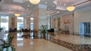 A spacious lobby with a marble floor, large columns, and hanging pendant lights. - Citylise Studio (Kuala Lumpur)