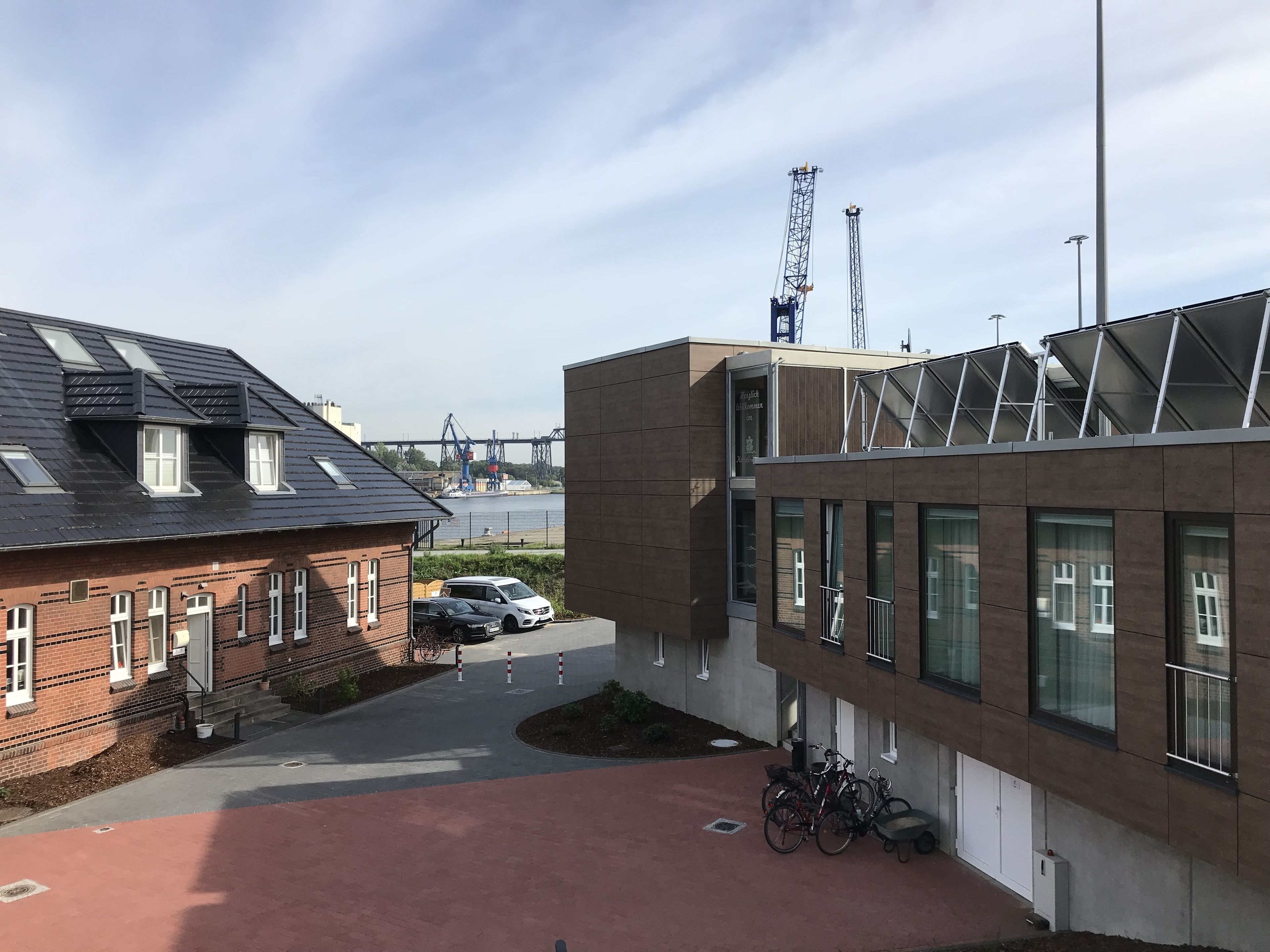 Een modern gebouw met een plat dak, grote ramen en een gevel van baksteen.