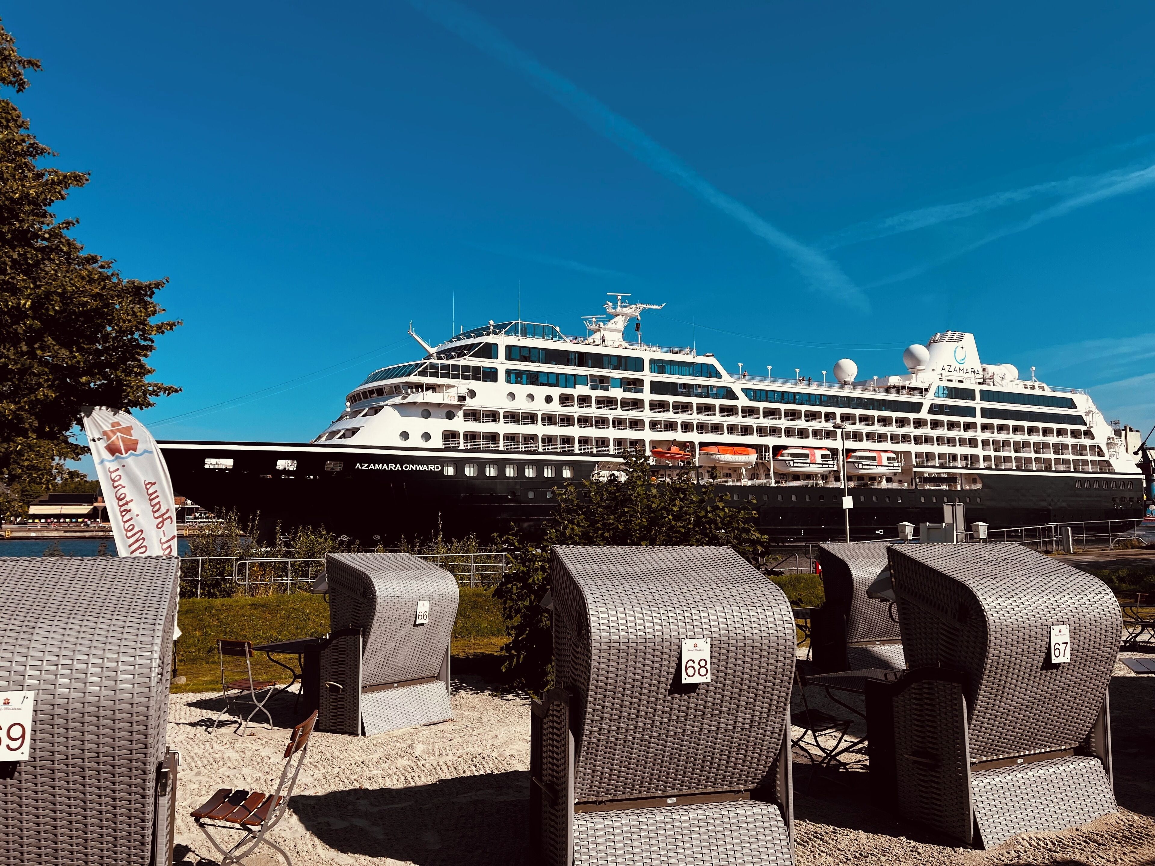 A large cruise ship named AZAMARA ONWARD docked at a port.