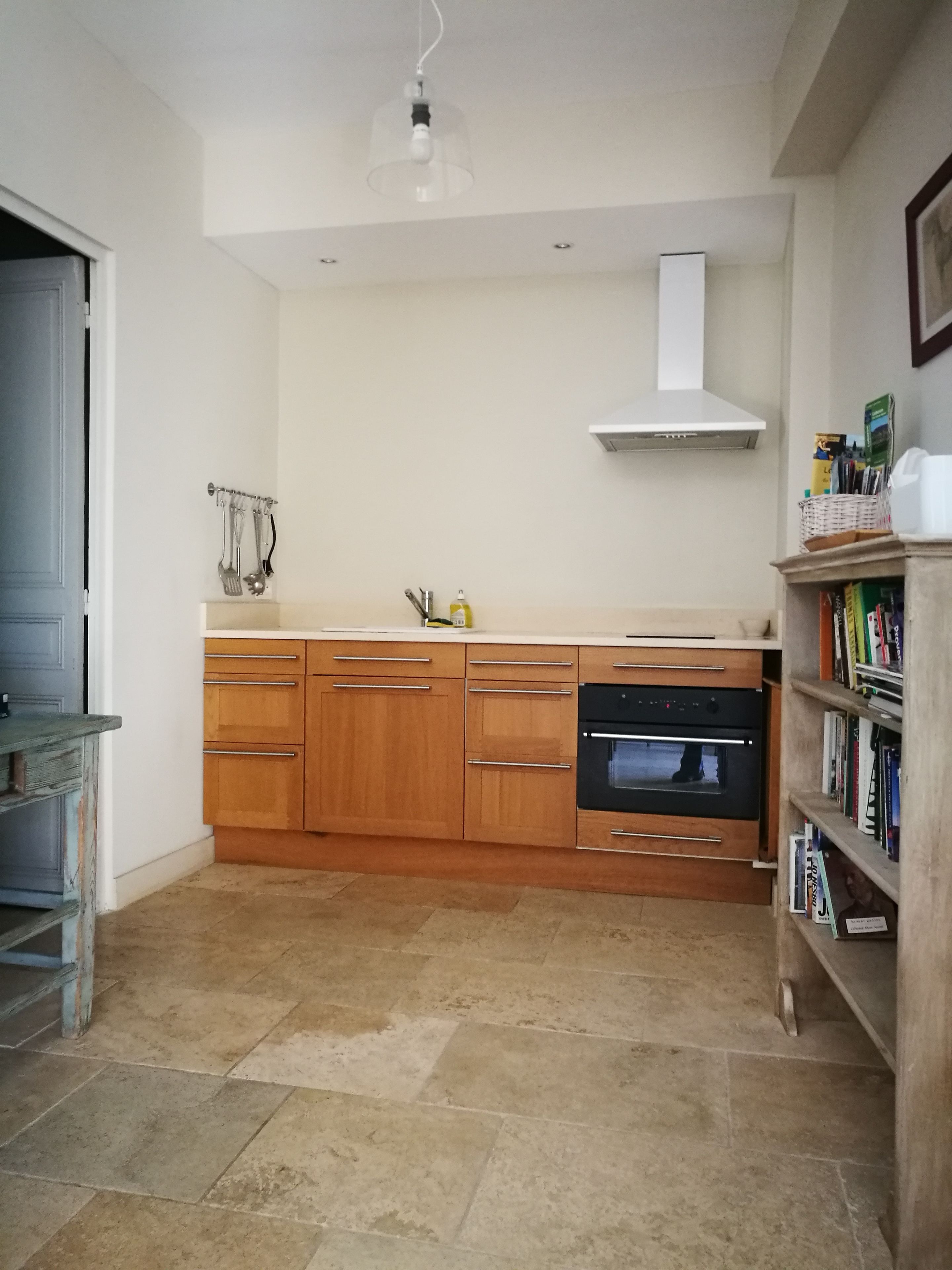 A modern kitchen with wooden cabinets, a built-in oven, and a sink.