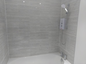 A modern bathroom with a bathtub, a shower, and a control panel. - Jaylets Premier Apartments, Leicester. (Leicester)