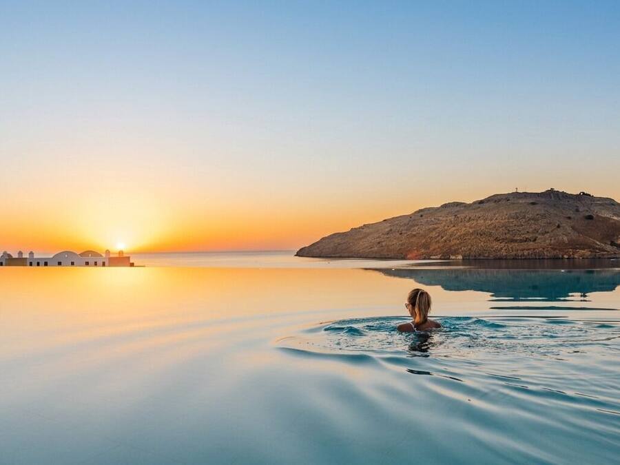 Una piscina techada, una piscina al aire libre, sombrillas