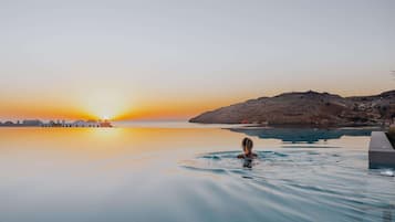 Een binnenzwembad, een buitenzwembad, parasols voor strand/zwembad