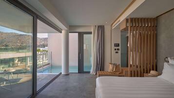 A modern hotel room with a large bed, a balcony with a pool view, and a sliding door leading to a shower area.