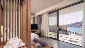 Una habitación de hotel moderna con un balcón grande, un banco de madera y un televisor.