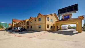 Un motel composé de plusieurs bâtiments à étages, d’un parking et d’un panneau indiquant une station-service Shell.