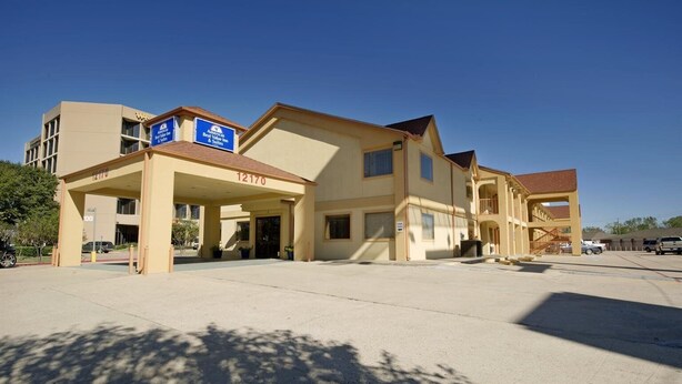 Un hôtel doté d’une entrée couverte, d’une enseigne indiquant qu’il s’agit d’un établissement « Best Value Inn », et d’un parking situé devant l’entrée.